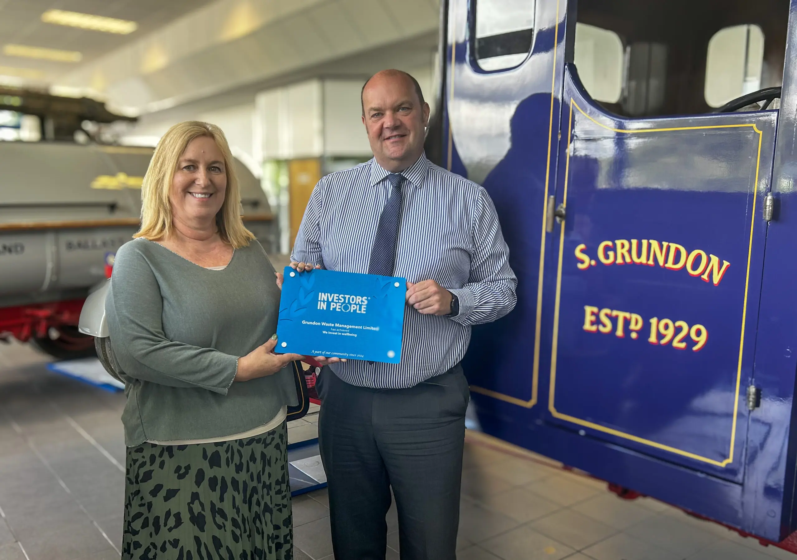 Lorna Fairbairn, Investors in People Practitioner (left), presents the "We invest in wellbeing" accreditation certificate to Clayton Sullivan-Webb, Grundon’s Managing Director (right)